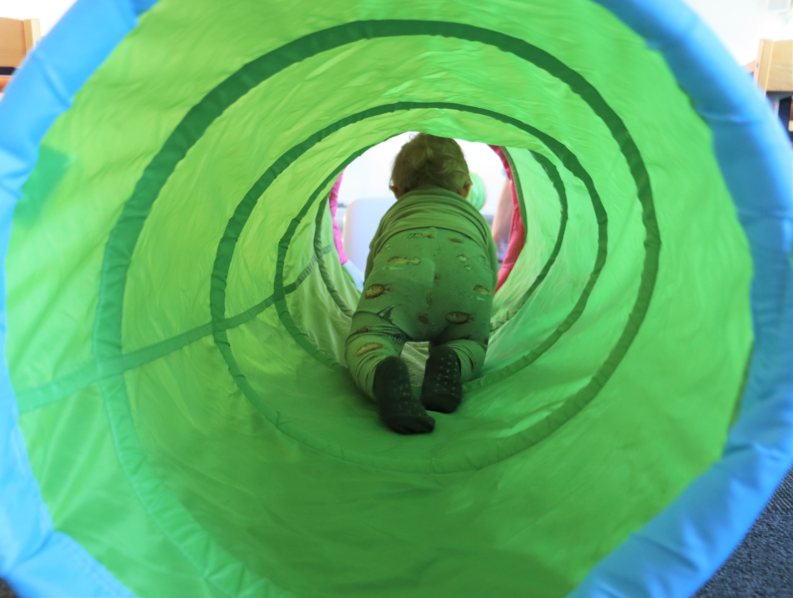 Dagplejebarn kravler igennem lege tunnel